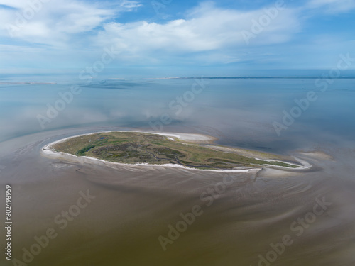 Aerial drone image of the uninhabited island Griend, part of world heritage the Wadden Sea in the Netherlands. Bird sanctuary, protected site, dunes, tidal stream, beach and sand bank in reflection