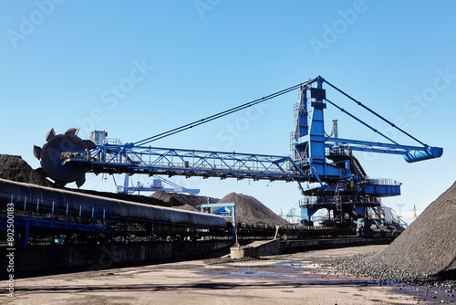 Combined stacker and reclaimer with bucket-wheel boom for stacking and reclaiming.