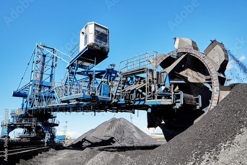 Bucket wheel stacker reclaimer in maritime bulk terminal of coal harbor.