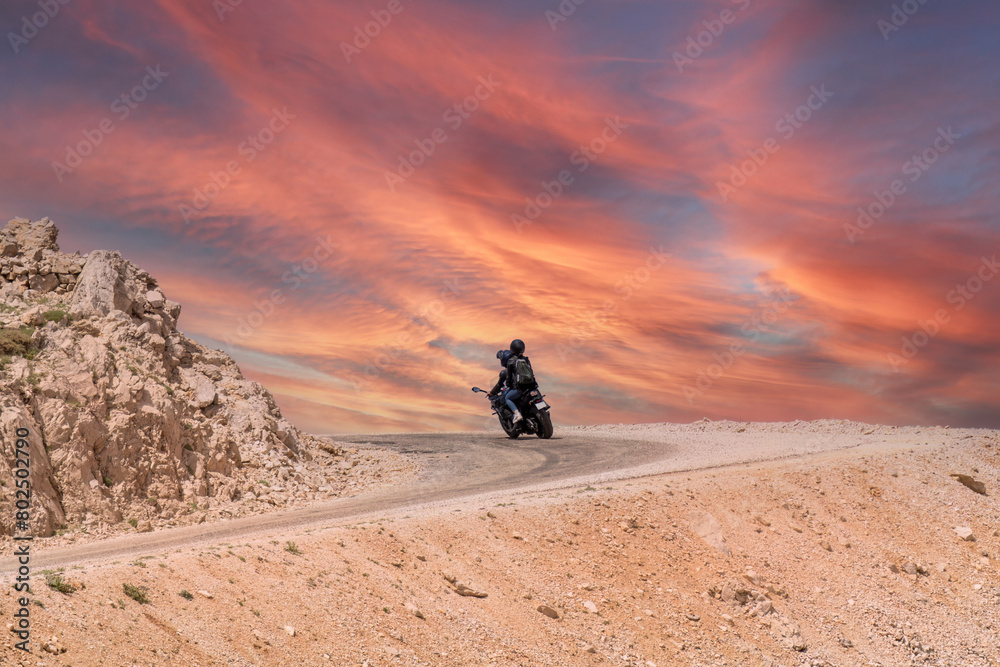 Two lovers on a motorbike coming round a bend in the road Two lovers on a motorbike coming round a bend in the road