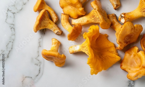 macro shot of scattered chanterelle mushrooms on a white marble table top view