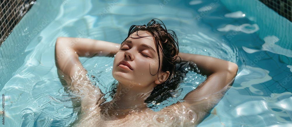 Portrait of a beautiful woman relaxing in the swimming pool in the morning