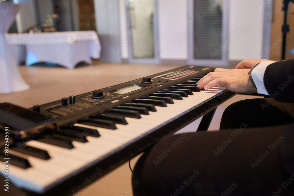 Obraz premium A pianist in a suit plays the keyboard with skilled hands