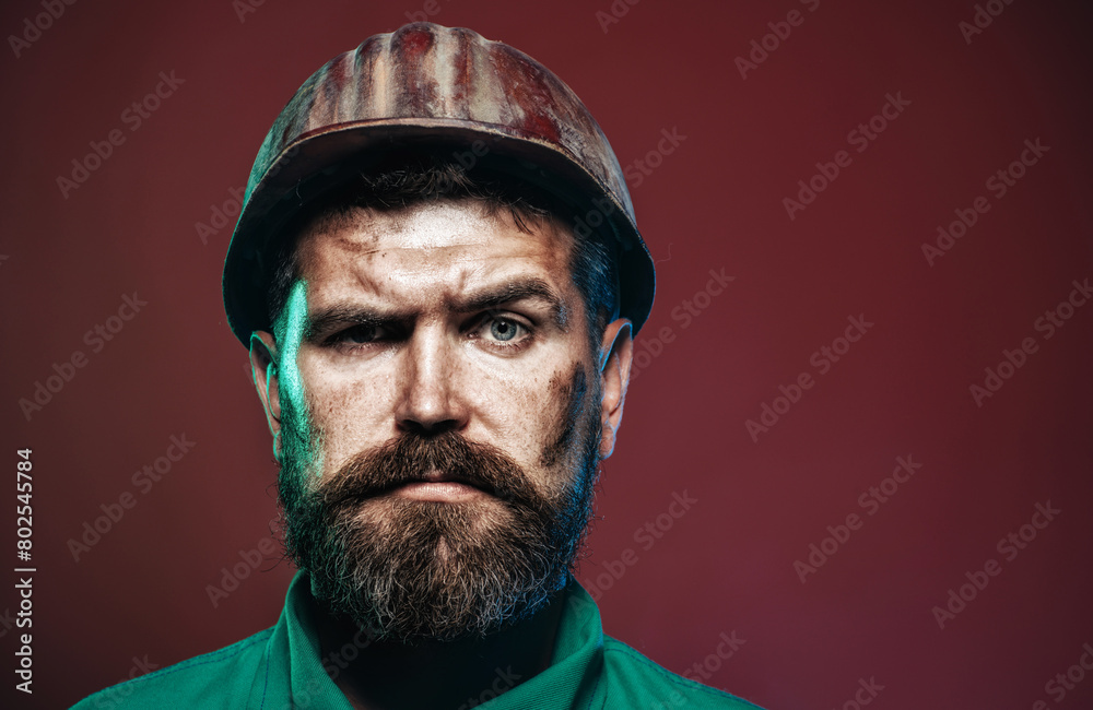 Man builder. Closeup portrait of serious male architect, contractor or engineer in safety helmet. Handsome construction worker in building hard hat. Bearded foreman or repairman in protective hardhat. Man builder. Closeup portrait of serious male architect, contractor or engineer in safety helmet. Handsome construction worker in building hard hat. Bearded foreman or repairman in protective hardhat.