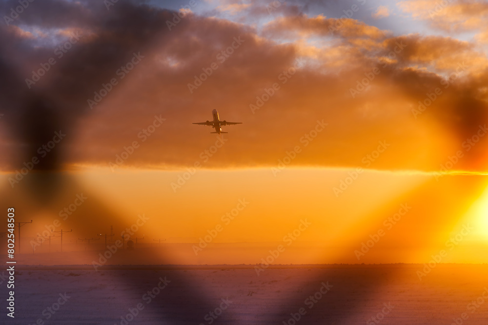 The silhouette of an airplane during takeoff in a protected area behind a fence. The concept of air travel bans. Sanctions in aviation The silhouette of an airplane during takeoff in a protected area behind a fence. The concept of air travel bans. Sanctions in aviation