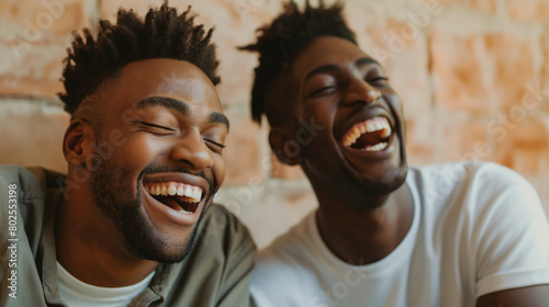 A candid waist-high view image showcasing the bright smiles of a couple of men, captured in a moment of shared laughter and joy against a neutral background, their genuine expressi © Nati