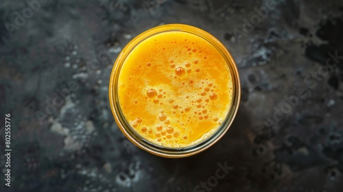 Smoothies mango, orange and carrot in a glass jar. Top view of a freshly prepared drink photo