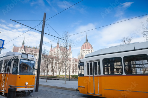 Selective blur on Budapest trams, called Villamos, on a tram stop in front of the hungarian parliament in Budapest. It is the main public transportation network of the hungarian capital city. photo