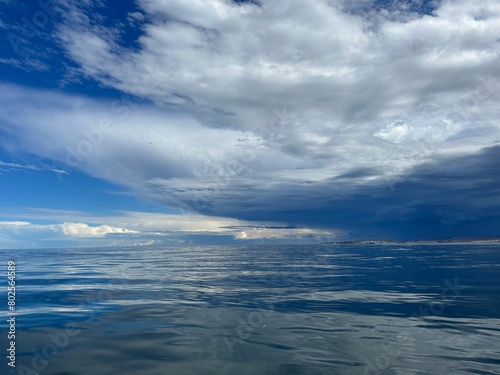 Mar sereno y reflejo del cielo nublado  © Juliana