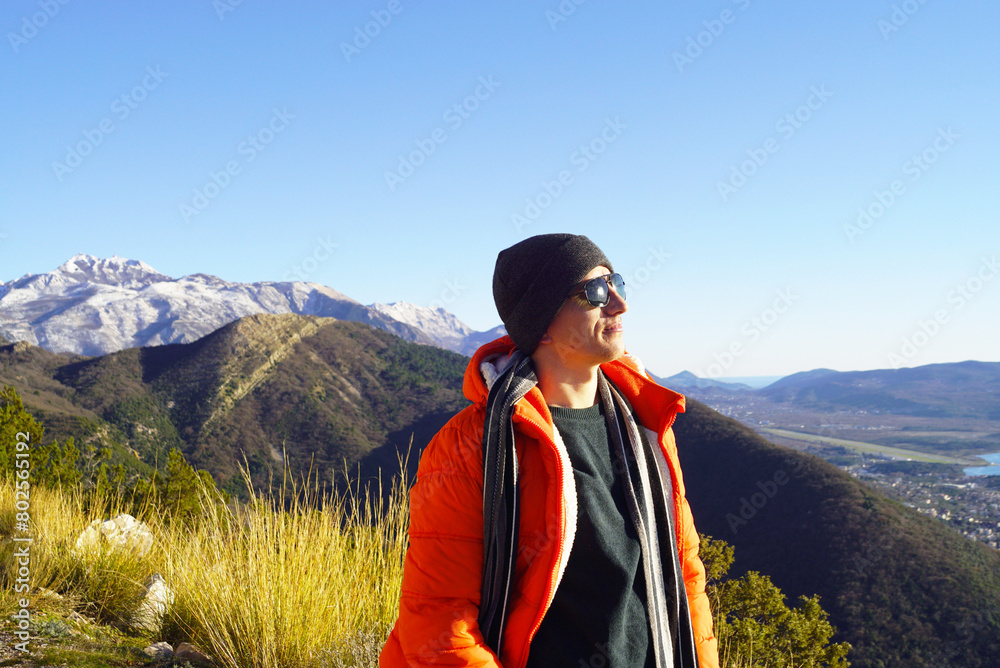 Portrait of a smiling tourist enjoying the view in the mountains. A man while hiking in the vicinity of the city of Tivat (Bay of Kotor, Montenegro),