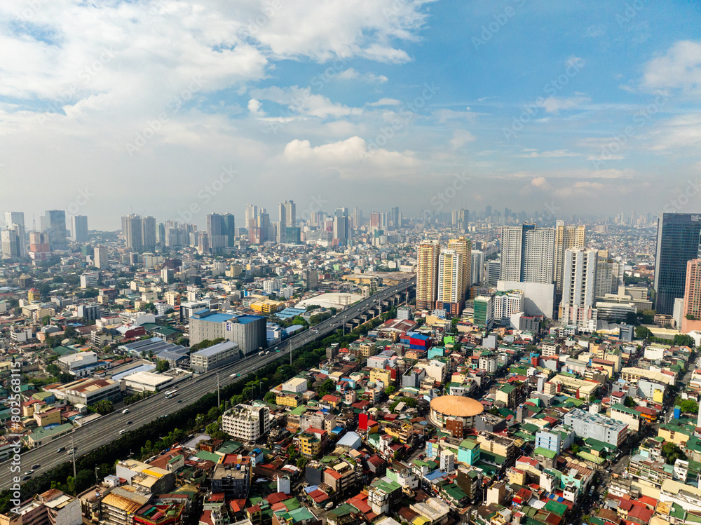 Highway with vehicles. Highrise buildings and residential area. Metro Manila, Philippines.