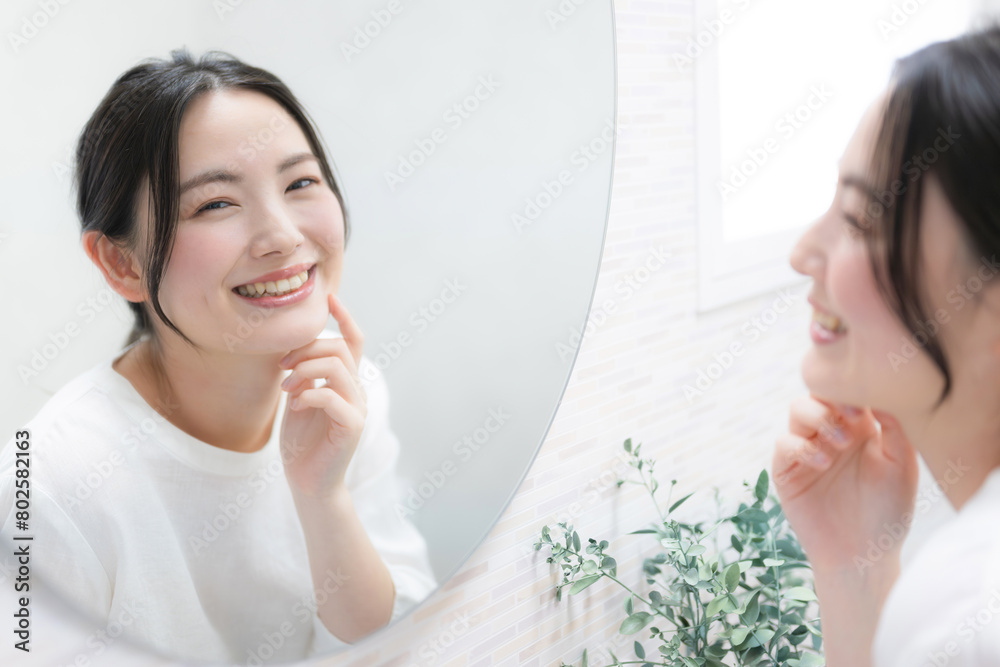Woman looking in the mirror and concerned about the texture of her skin Image of skin care and beauty Looking at the camera Woman looking in the mirror and concerned about the texture of her skin Image of skin care and beauty Looking at the camera