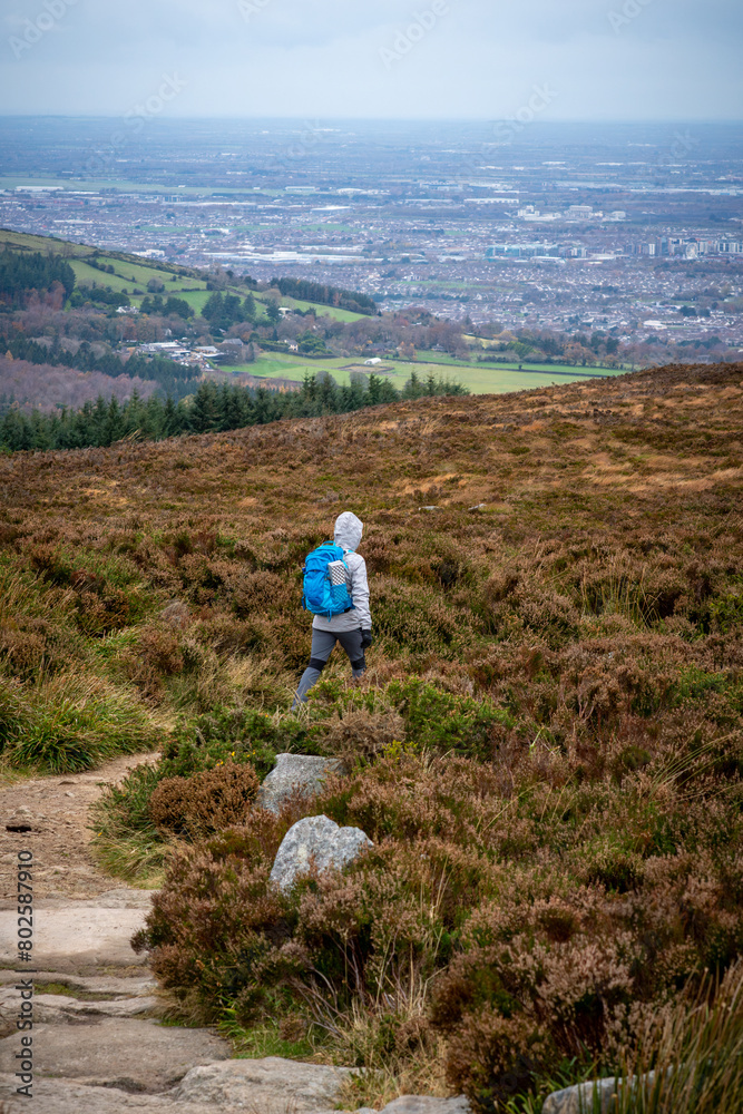 Female hiker in bad irish weather walking in dublin mountains path