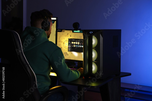 Man playing video games on computer at table indoors