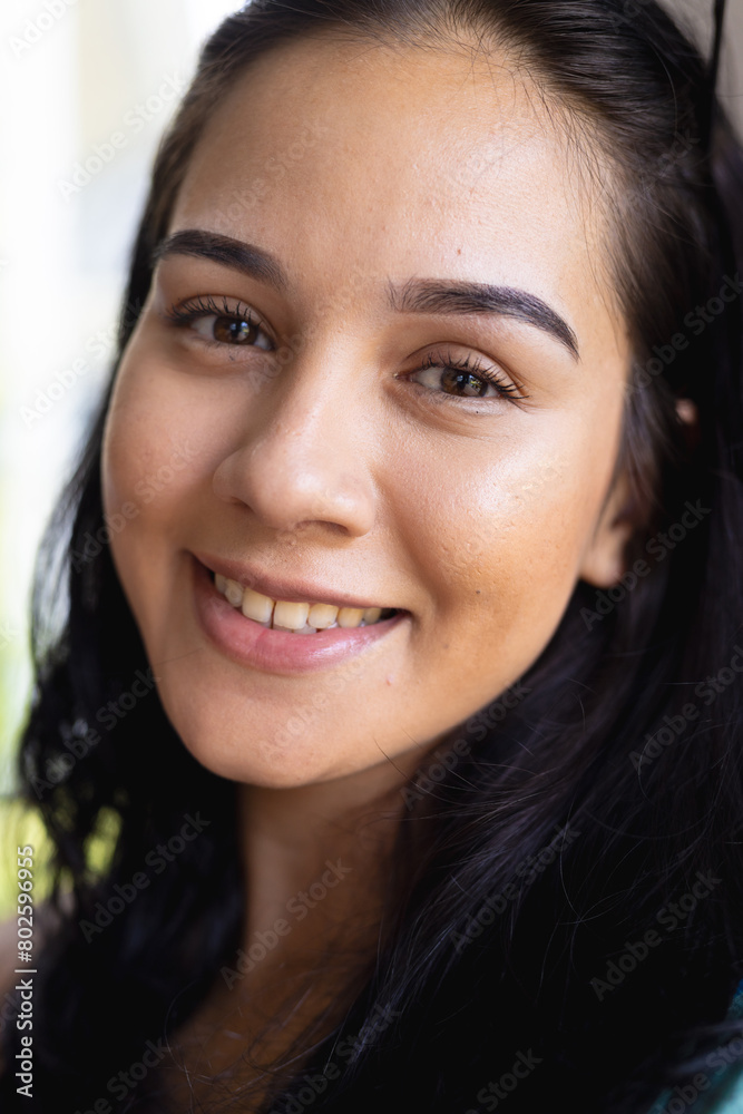 Young biracial woman with cheerful expression, wearing light makeup at home Young biracial woman with cheerful expression, wearing light makeup at home
