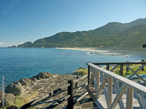 Yakushima coast panorama on sunny day, Inakahama sandy beach turquoise sea water, blue sky, distant Kuchierabujima isalnd