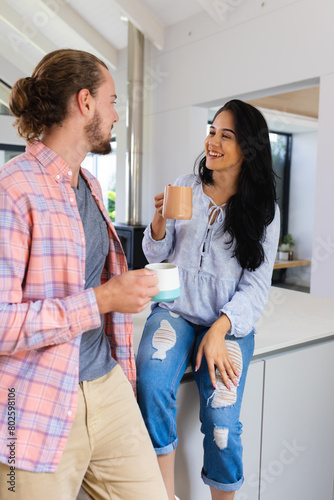 Diverse couple enjoying coffee in kitchen at home photo