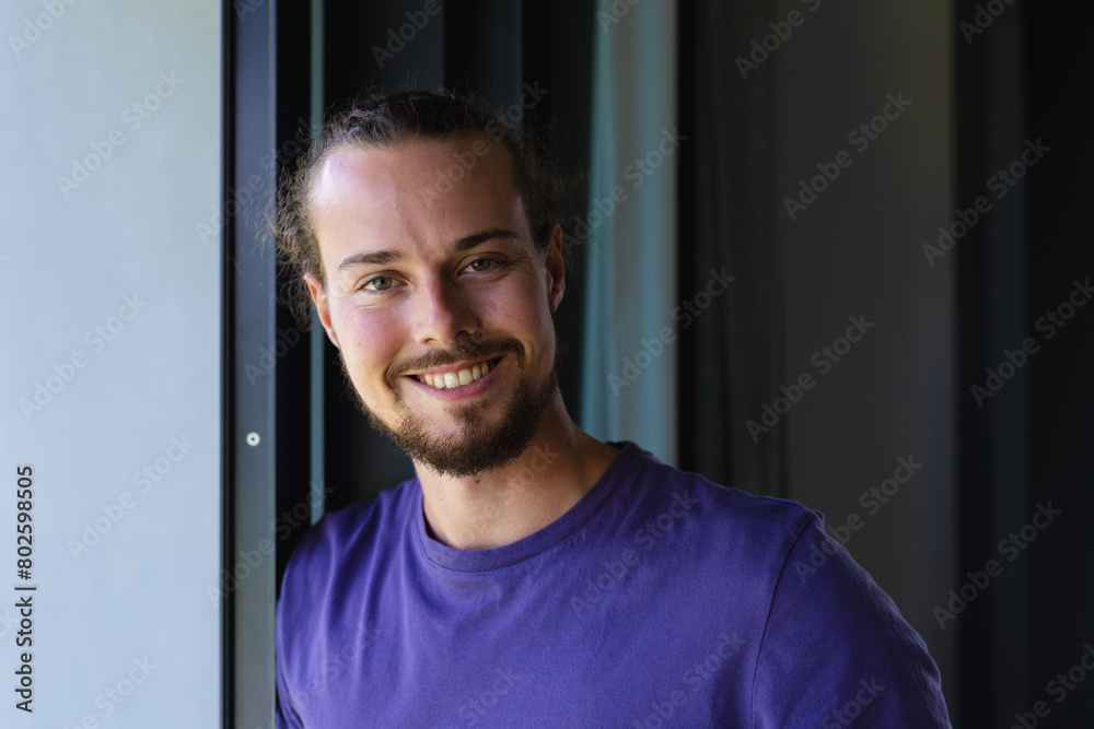 A young Caucasian male leaning against door frame at home A young Caucasian male leaning against door frame at home