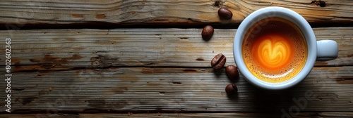 A cup of coffee seen from above on a plain wooden table top.  photo