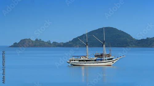 sea view with blue sea and sky and in the middle there is a white ship sailing and behind it there is a green hill in Labuhan Bajo © Abdurrahman