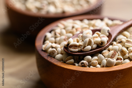 Dried Job's tears or adlay millet in wooden spoon and bowl photo