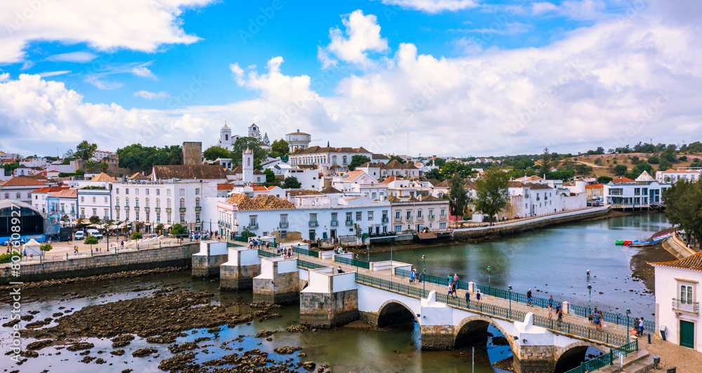 View on historic town of Tavira with Roman bridge over River Gilao, Algarve, Portugal. Cityscape of the Tavira old town with Clock tower, St Marys church, Algarve region, Portugal.