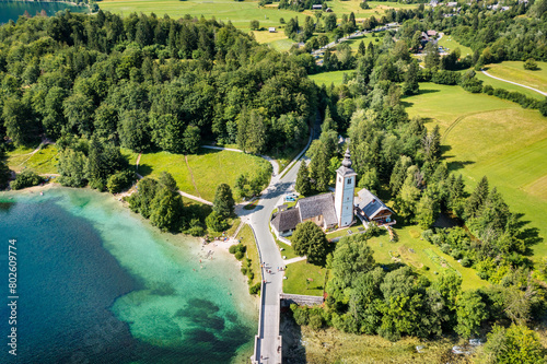 Aerial view of Bohinj lake in Julian Alps. Popular touristic destination in Slovenia. Bohinj Lake, Church of St John the Baptist. Triglav National Park, Julian Alps, Slovenia. photo