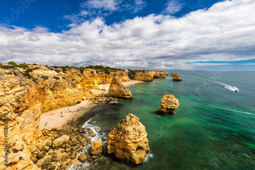 Natural caves at Marinha beach, Algarve Portugal. Rock cliff arches on Marinha beach and turquoise sea water on coast of Portugal in Algarve region.