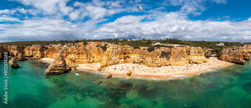Praia da Marinha, beautiful beach Marinha in Algarve, Portugal. Navy Beach (Praia da Marinha) with flying seagulls over the beach, located on the Atlantic coast in Lagoa Municipality, Algarve.