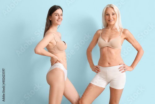 Body positive women in underwear on blue background