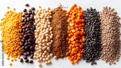 Assorted legumes and cereals, such as beans, peas, lentils, barley, and spelt, arranged on a white surface.