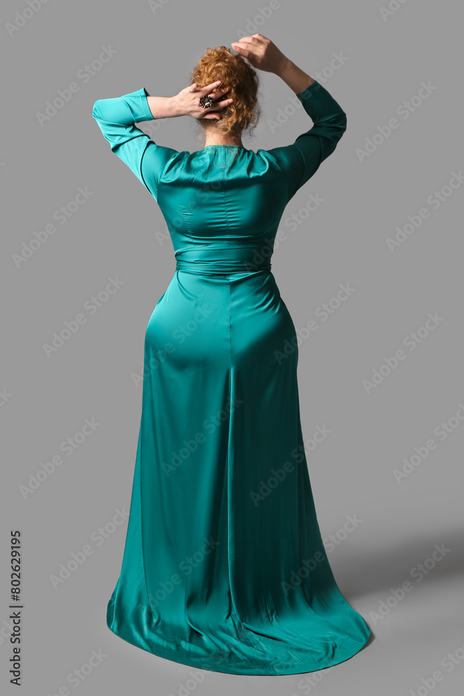 Young woman in stylish turquoise dress on grey background, back view Young woman in stylish turquoise dress on grey background, back view