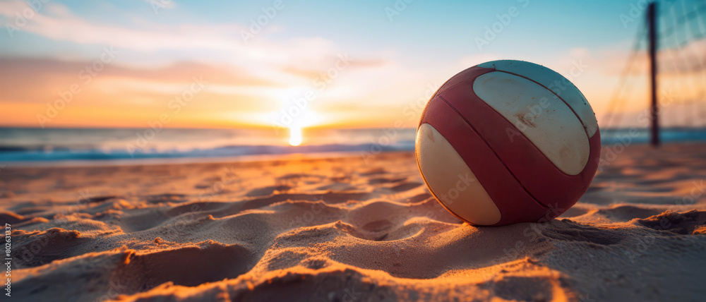 Detailed shot of a volleyball on a sandy beach at sunrise,