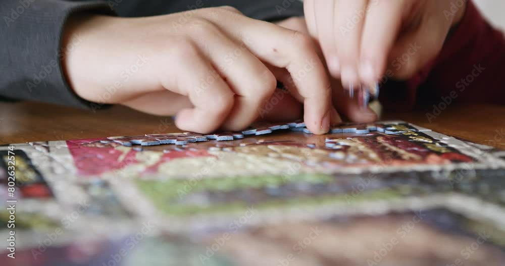 Two boys engage in teamwork as they focus on assembling a colorful jigsaw puzzle on a wooden table, their hands carefully selecting pieces.