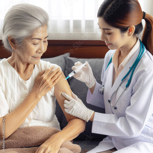 Asian female doctor injecting vaccine to senior woman patient in hospital ward.