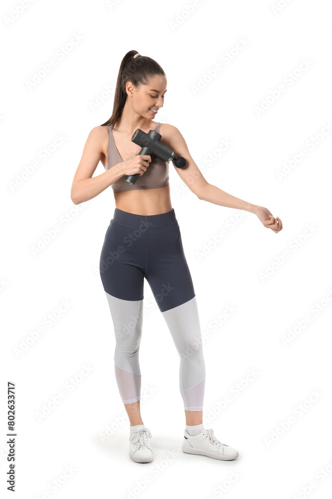Sporty young woman massaging her arm with percussive massager on white background Sporty young woman massaging her arm with percussive massager on white background