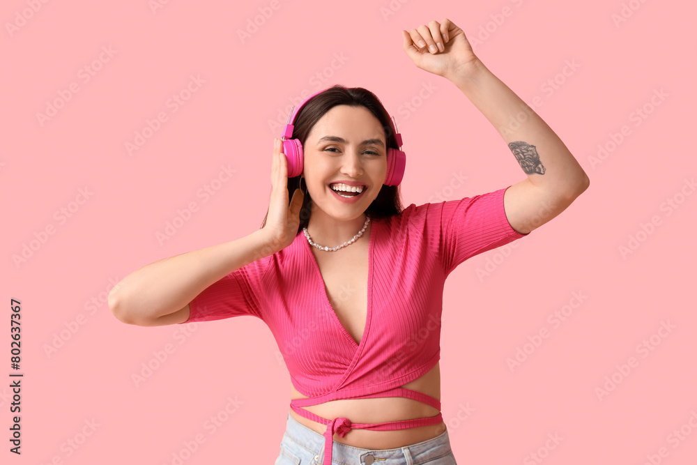 Smiling young woman in headphones on pink background Smiling young woman in headphones on pink background