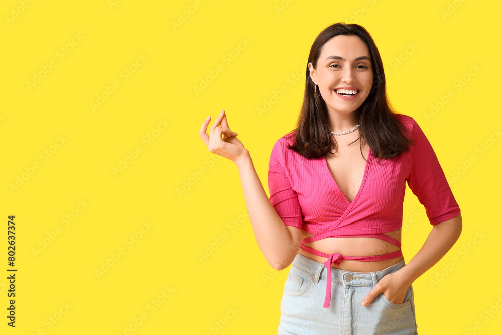 Smiling young woman on yellow background Smiling young woman on yellow background