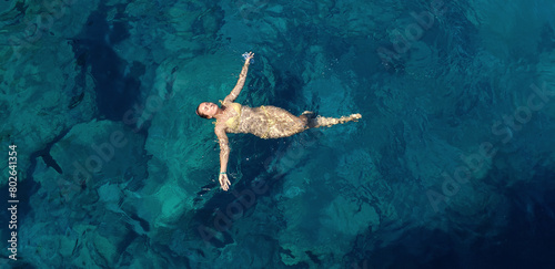 A woman floating and relaxing in the sea  on a sunny day