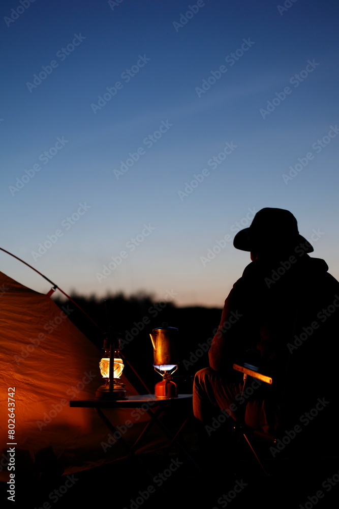 Obraz premium 夕暮れのキャンプを楽しむ男性