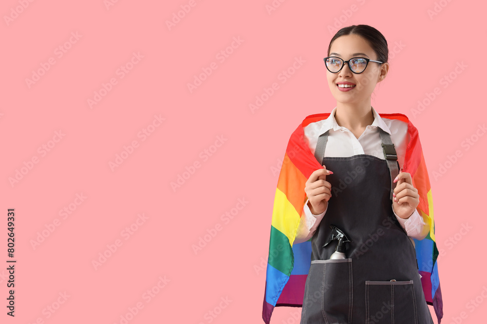 Female Asian hairdresser with LGBT flag on pink background Female Asian hairdresser with LGBT flag on pink background
