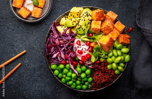 Vegan Buddha Bowl for balanced diet with roasted tofu, red quinoa, vegetables, legumes, seeds and sprouts. Black table background, top view © 5ph