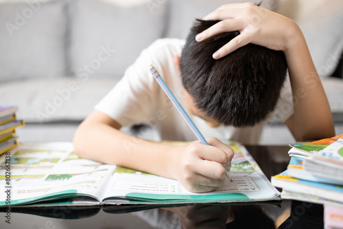 Konstfotografi Asian kid boy holding head in hand,schoolboy study hard,tired from studying,Stre
