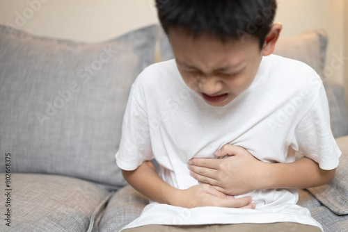 Фотография Child boy holding his stomach,kid suffering from stomachache,abdominal disease,p