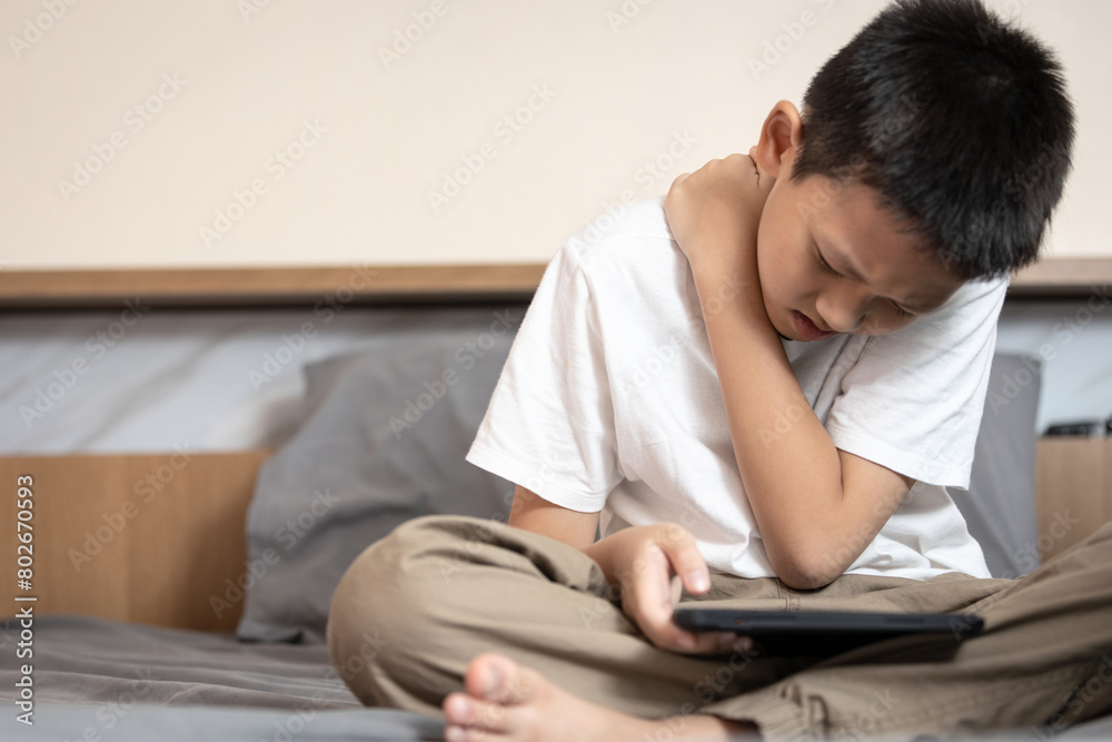 Asian boy suffering from neck muscle and shoulder pain,aching in spinal back,sitting and bending his back,poor posture,tilting his head down long time while playing game on mobile phone,bad position Asian boy suffering from neck muscle and shoulder pain,aching in spinal back,sitting and bending his back,poor posture,tilting his head down long time while playing game on mobile phone,bad position