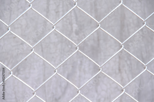Metal mesh fence grey texture on concrete wall background