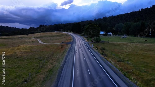Drone shot of rural alpine highway road with dark and dramatic storm clouds on the horizon in Crackenback, NSW, Australia photo