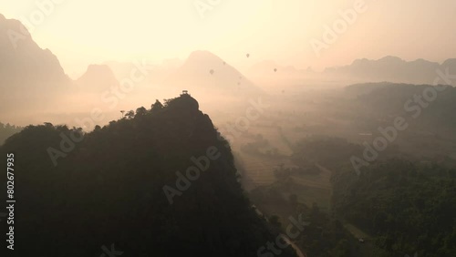 golden sunrise behind cliffs in Vang Vieng, the adventure capital of Laos photo