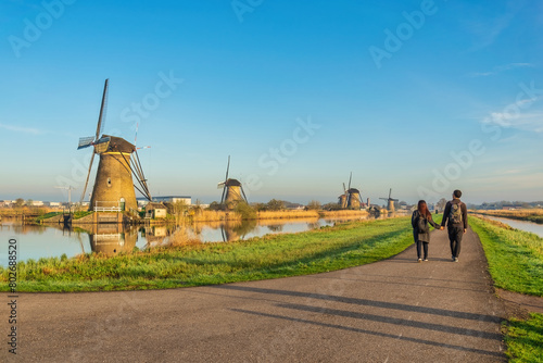 Dutch Windmill landscape at Kinderdijk Village Netherlands with love couple walking