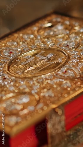 The holy book of the Bible in a golden binding on the throne in a church or temple. Greek catholic parish, Ukraine. Vertical video photo